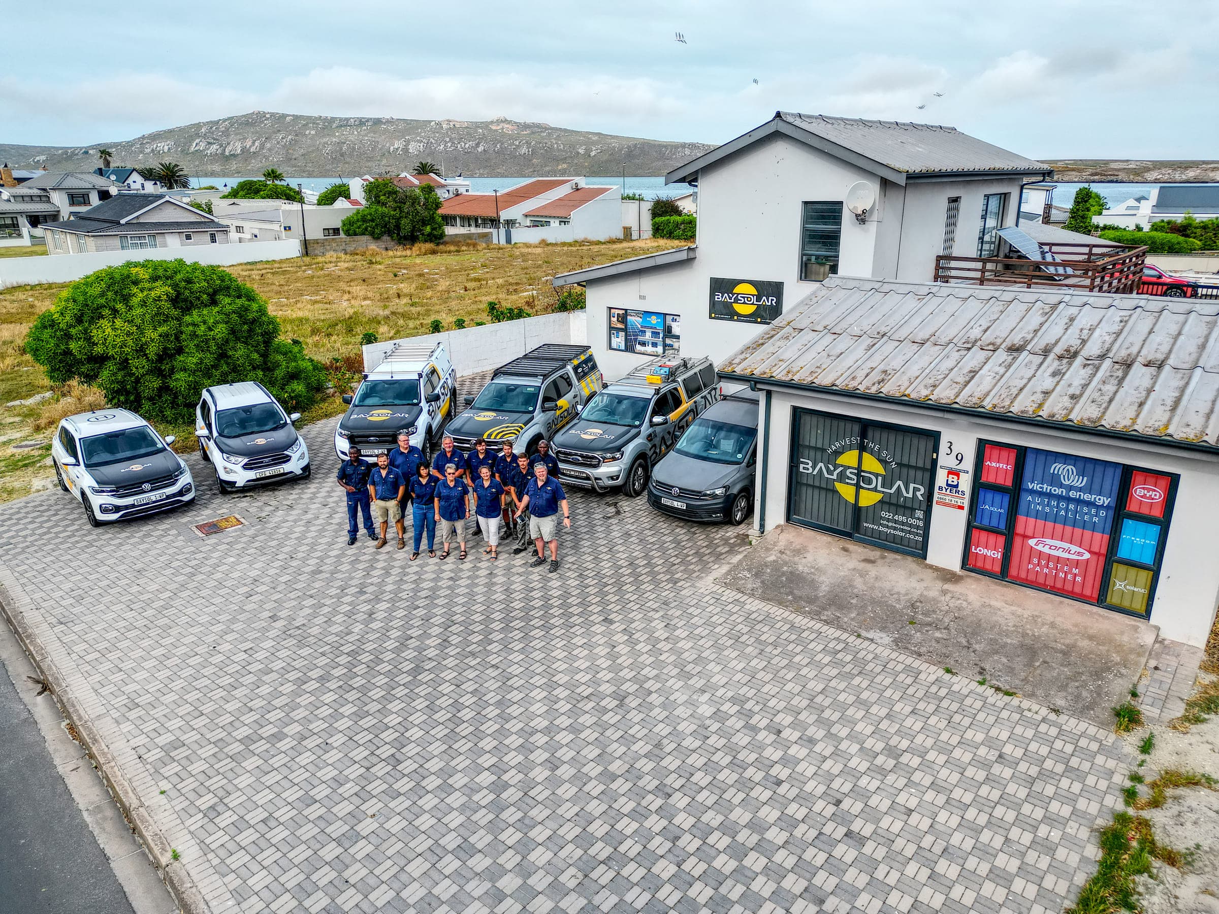 The Bay Solar team and branded fleet outside the Langebaan office at 39 Main Street